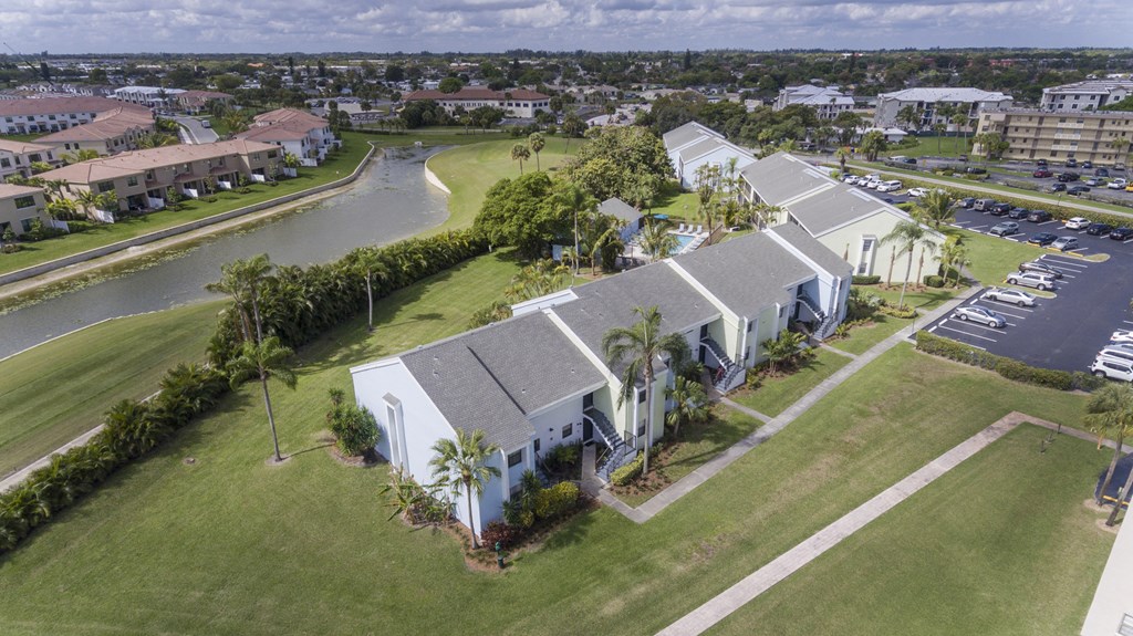 A bird's eye view of a residential area with houses and a parking lot.